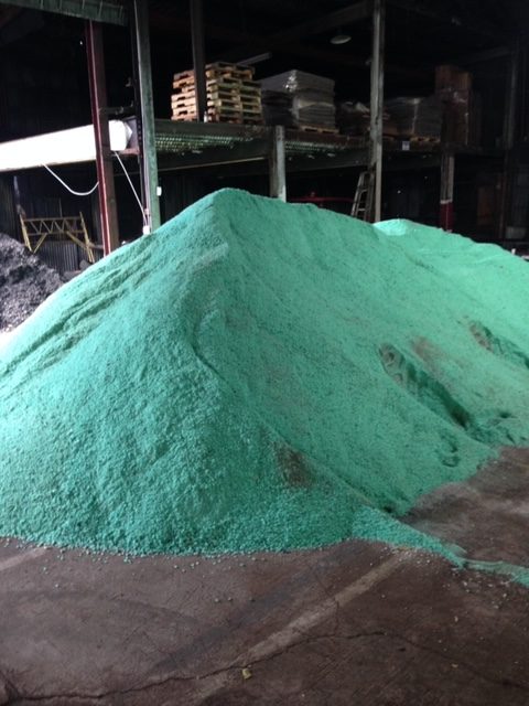 Pile of green Clearlane rock salt in bulk rock salt supplier distrubtion warehouse